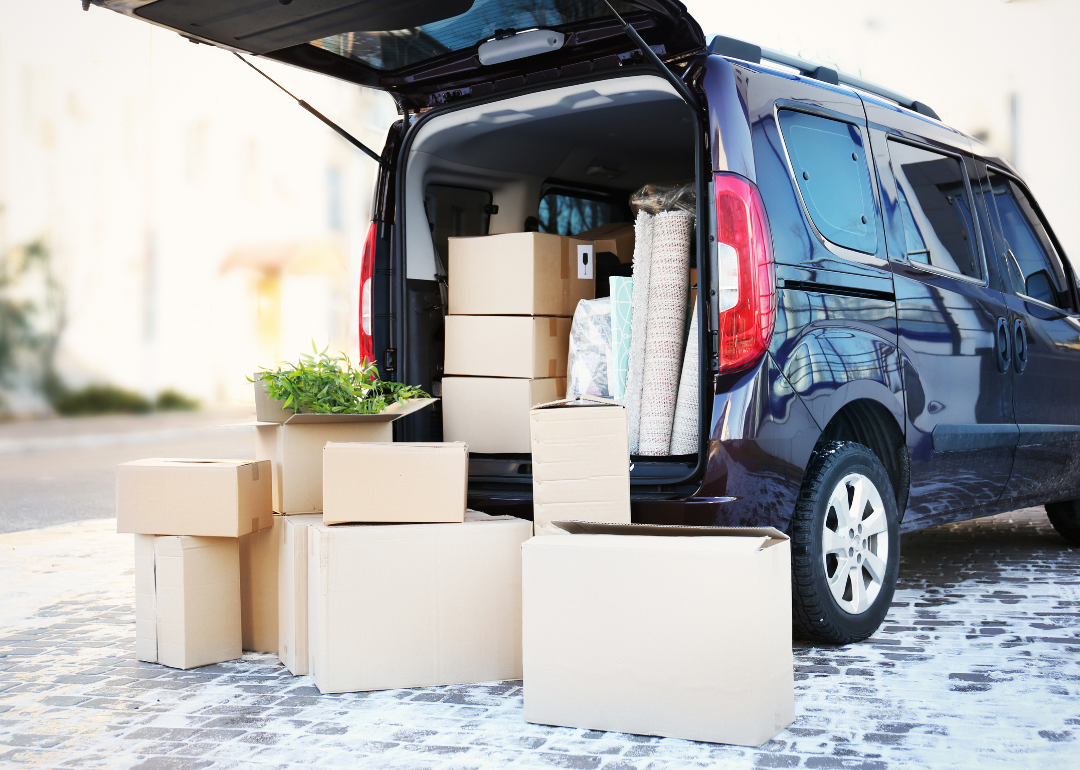 Boxes being packed in the back of a large SUV.